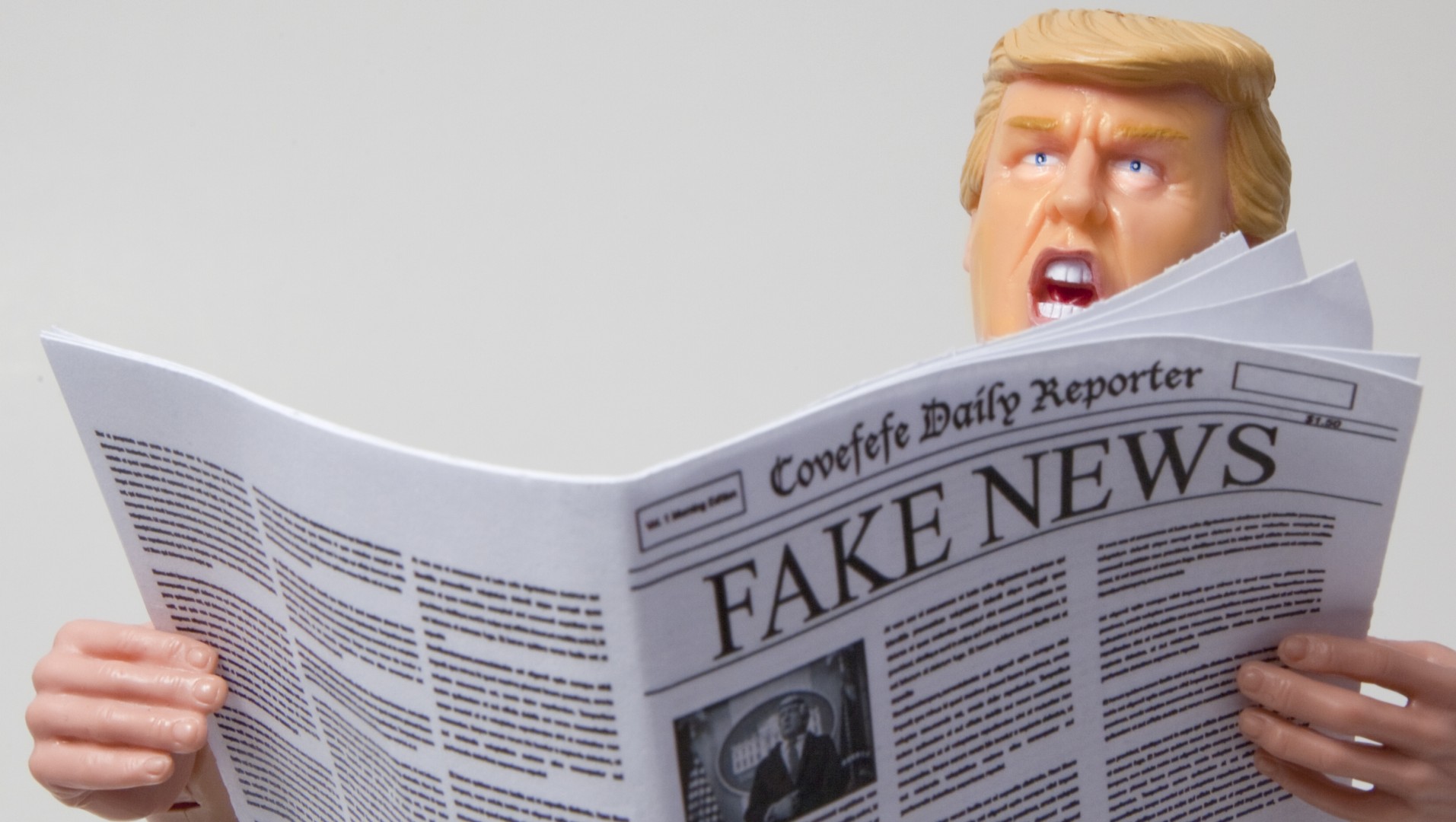 A caricature figure is holding a newspaper titled "Covfefe Daily Reporter" with the headline "FAKE NEWS.