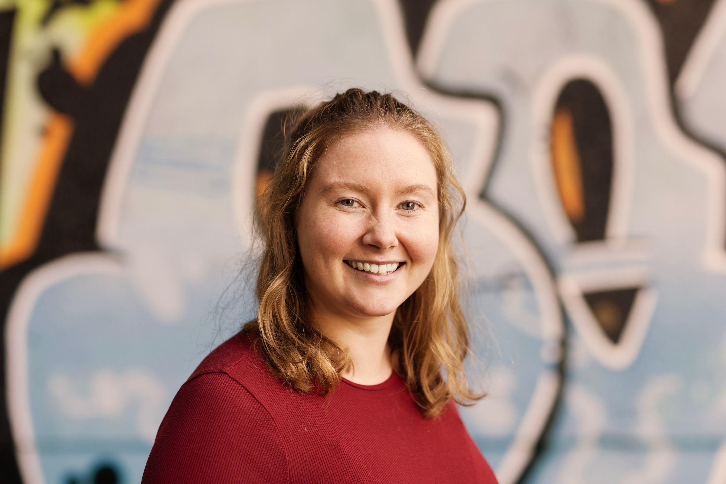 A photo of Andrea Switzer with a graffiti background.