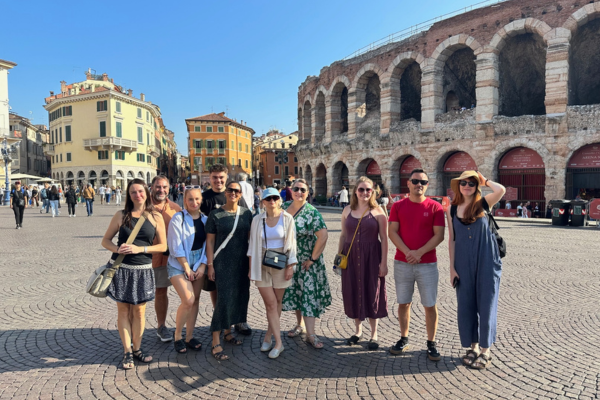A picture of a group of people standing in front of a Roman amphitheater in Verona.